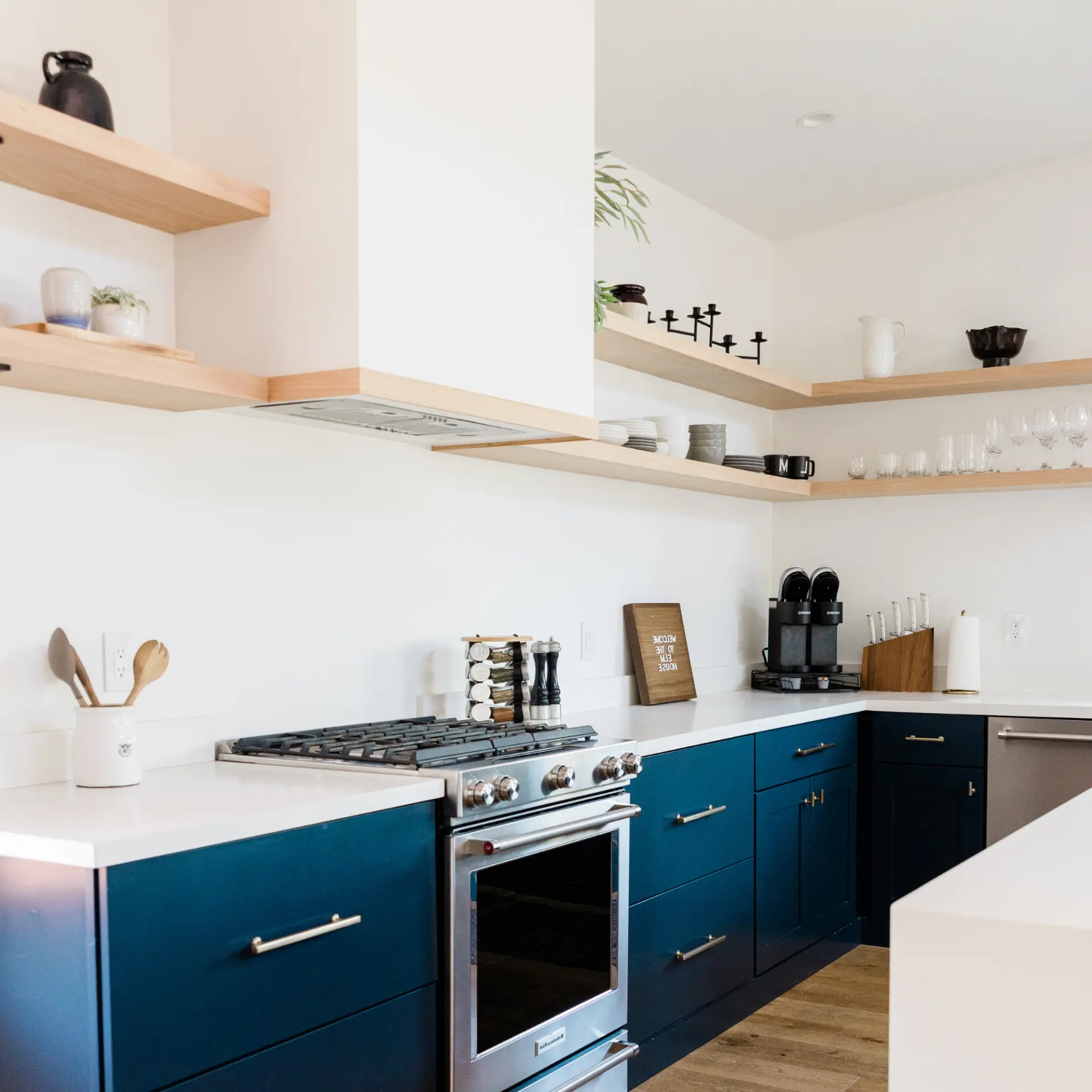 Warm, sunlit kitchen with navy island and white countertops